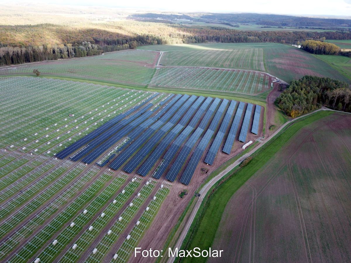 Luftbild eines sehr großen Solarparks auf grüner Fläche im Bau.
