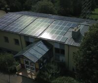 Blick auf das Dach einer Kita mit Solarmodulen.