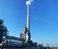 Schornstein einer Chemieanlage vor blauem Himmel.