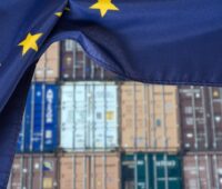 Container gestapelt, davor EU-Flagge, Symbol für Schutzmaßnahmen für Solarindustrie