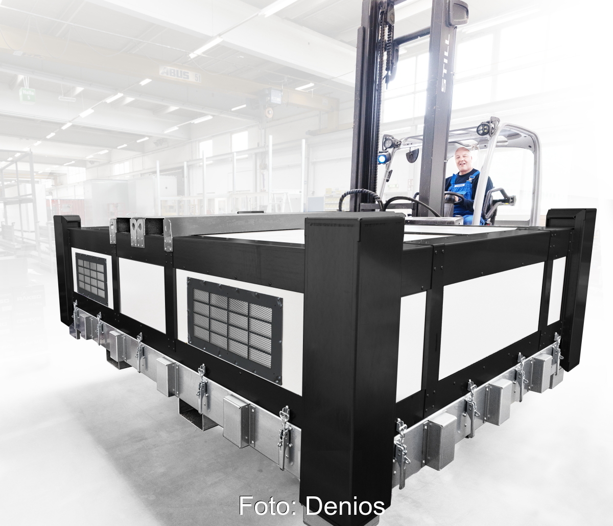 Stapler befördert große Transportbox für Batterien