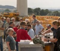 Im Bild Bürger:innen beim Bau einer Windenergieanlage, die Bürgerbeteiligung an Windparks und Photovoltaik-Freiflächenanlagen erhöht die Akzeptanz.