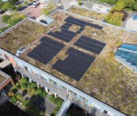 Gründach mit Photovoltaikanlage auf einem Schuldach in Hückelhoven - im Innern des Gebäudes befindet sich ein Batteriespeicher.
