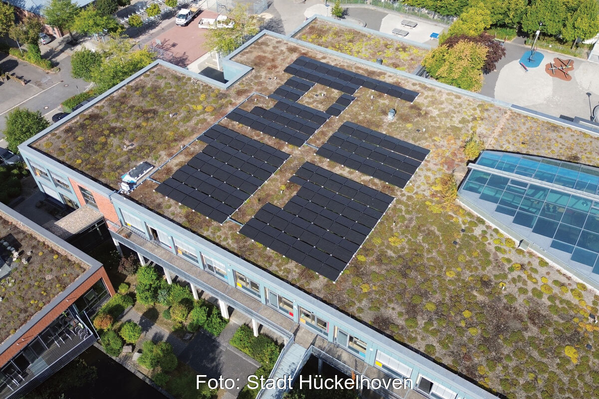Gründach mit Photovoltaikanlage auf einem Schuldach in Hückelhoven - im Innern des Gebäudes befindet sich ein Batteriespeicher.