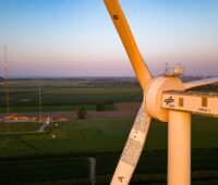 Windenergierotoren in 150 Meter in Nahaufnahme und in Nordseeküstenlandschaft im Abendlicht.