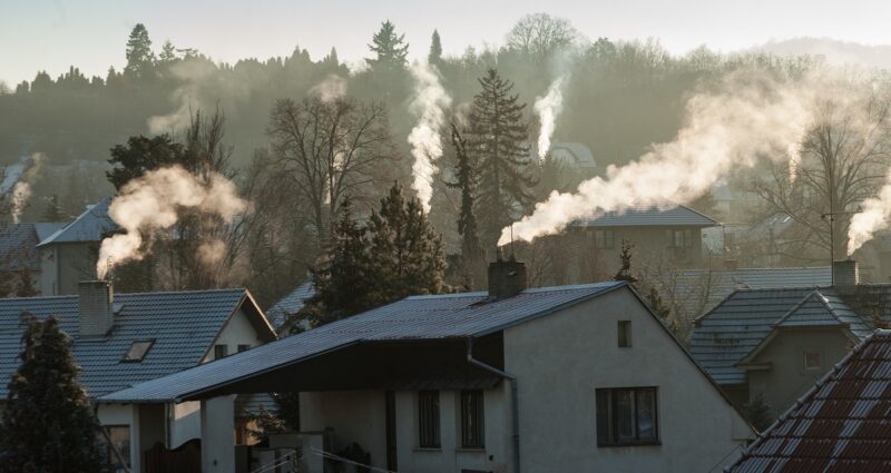 Zu sehen sind qualmende Schornsteine einer Siedlung. Für Klimaschutz und Energiesicherheit sind Maßnahmen zum Öl- und Gassparen nötig.