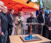 Im Bild sind Bundeskanzler Olaf Scholz und weitere prominente Politiker:innen, die die Inbetriebnahme vom Geothermie-Heizwerk in Schwerin besuchten.
