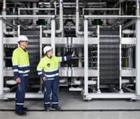 Im Bild zwei Dekra Certification Beschäftigte in der 20-Megawatt-Elektrolyseanlage in Oberhausen.
