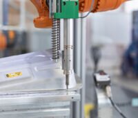 Detailaufnahme eines Schraubendrehers in einer Schraube in einem Metallgehäuse - Detailaufnahme aus der Roboter-Zelle für das Recycling von Batterien
