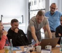 Menschen an einem Bildschirm testen Densys Connect, eine Plattform für die Photovoltaik-Projektabwicklung.