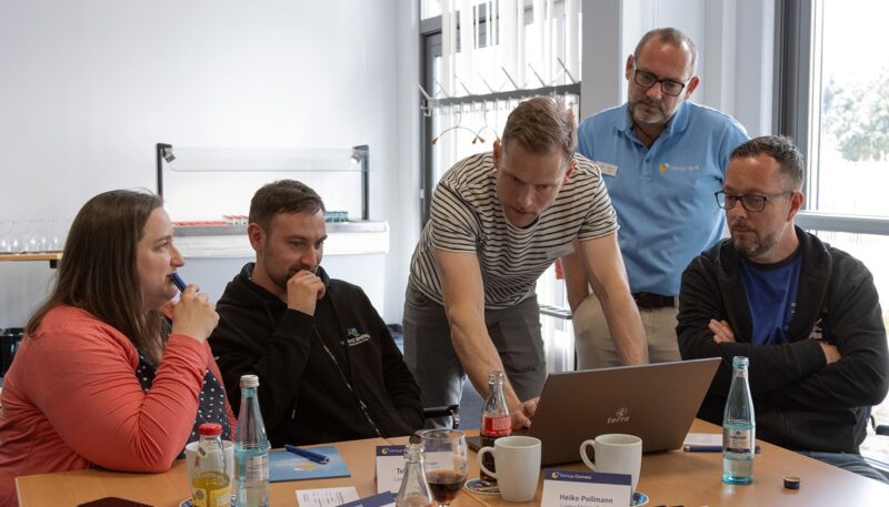 Menschen an einem Bildschirm testen Densys Connect, eine Plattform für die Photovoltaik-Projektabwicklung.