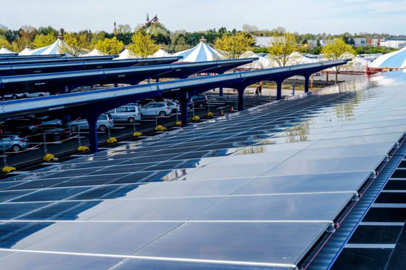 Blick über solarbedeckten Parkplatz vor Zirkuszelt.