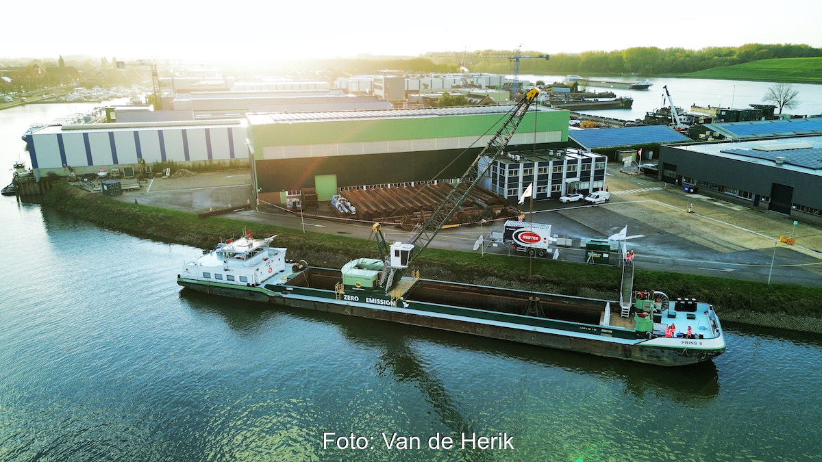 Aus der Vogelperspektive liegt ein Seilbaggerschiff am Pier im aufgehenden Sonnenlicht.