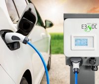 Ein Elektro-Auto steht neben einer Ladestation von E3/DC. Die Fahrzeugbatterie wird gerade geladen.