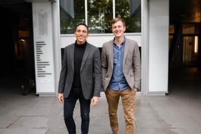 Die Gründer der Einhundert Energie, Ernesto Garnier und Markus Reinhold stehen lächelnd vor einem Haus.