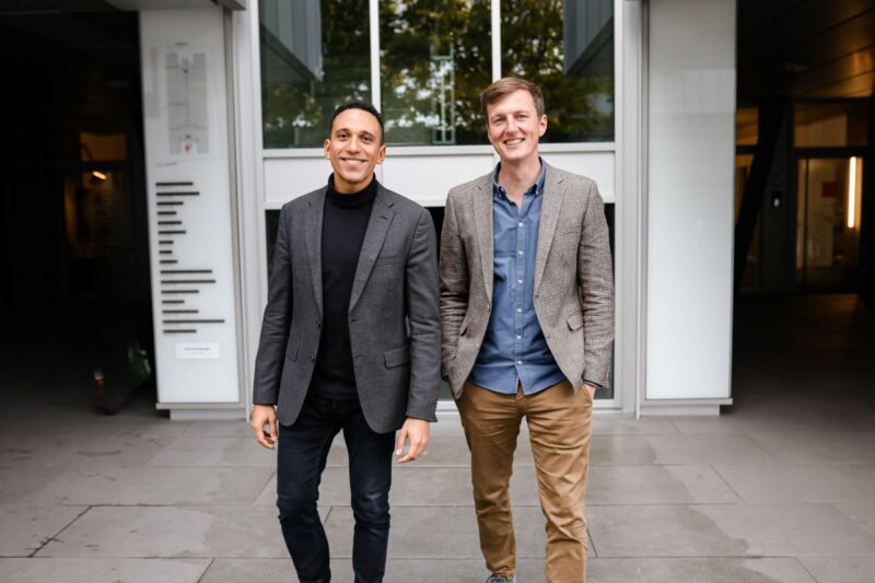 Die Gründer der Einhundert Energie, Ernesto Garnier und Markus Reinhold stehen lächelnd vor einem Haus.