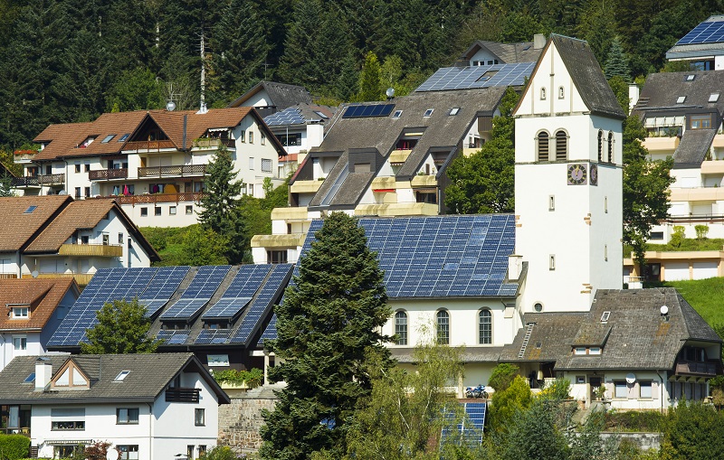 Zu sehen ist das „Schönauer Schöpfungsfenster“. Es handelt sich um zwei Ü20-Photovoltaik-Anlagen auf den Dächern der Kirche und des Gemeindehauses in Schönau.