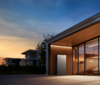 EcoFlow OCEAN 2 Batteriespeicher an einer Hauswand eines moderner Flachbau-Wohngebäudes in der Abenddämmerung mit Familie im Wohnraum.