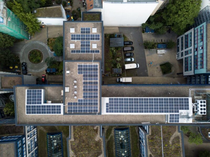 Blick auf das Dach eines Wohnblocks mit Photovoltaik aus der Vogelperspektive