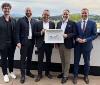 Offizielle stehen auf einer Dachterrasse der Firmenzentrale vom Photovoltaik-Projektentwickler Maxsolar.