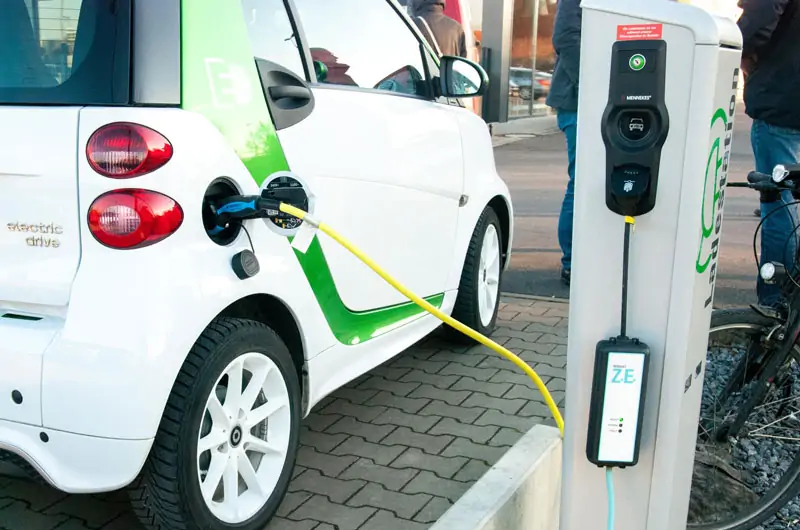 Zu sehen ist ein Auto an einer Ladestation, solche wie diese können von der Förderung der Ladeinfrastruktur von KMU profitieren.