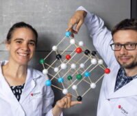 Zwei Wissenschaftler präsentieren ein Modell eines Kochsalzkristalls