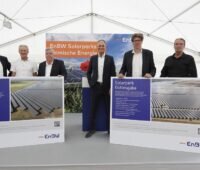 Zu sehen ist ein Gruppenfoto mit Offiziellen von der Einweihung der EnBW-Solarparks Alttrebbin und Gottesgabe in Neuhardenberg.