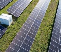 Ein Batteriespeicher in einem Photovoltaik-Feld, Enerfin bietet ein Komplettpaket für Betreiber von Solarparks an.
