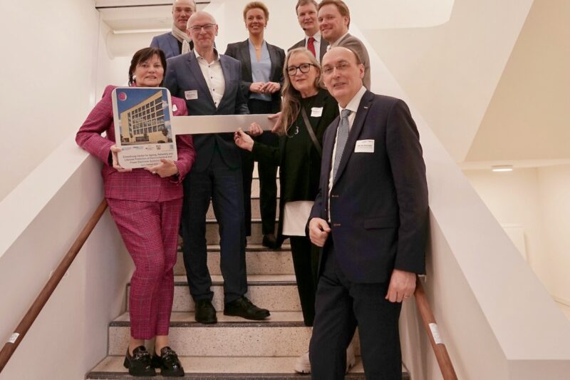 Gruppenfoto mit acht Menschen auf neuer Treppe - Einweihung am neuen Forschungszentrum für Batterie- und Leistungselektronik