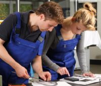 Zu sehen sind zwei junge Menschen. Das Foto illustriert den Flyer „EnergieJobs.NRW - Berufswelt Energie und Klimaschutz“.