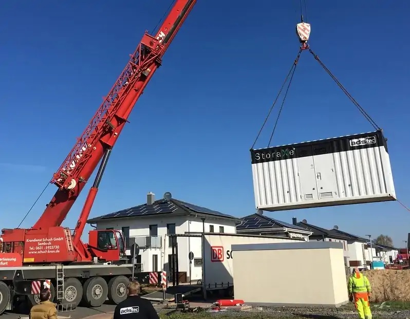 Zu sehen ist ein Speicher, der an einem Kran hängt. Die Energy Project Solutions soll in den Bereichen Photovoltaik und Speicher den Entega Vertrieb ergänzen.