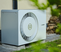 Eine Bosch-Wärmepumpe in lichtgrau vor einer hellen Hauswand. Enerix und Bosch kooperieren bundesweit für effiziente Wärmepumpenlösungen.