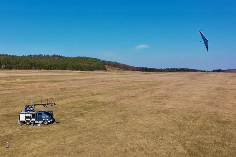 Wiese mit LKW mit Seilwinde und Drachen vor blauem Himmel: der 30-kW-Demonstrator der Flugwindkraftanlagen von EnerKite.