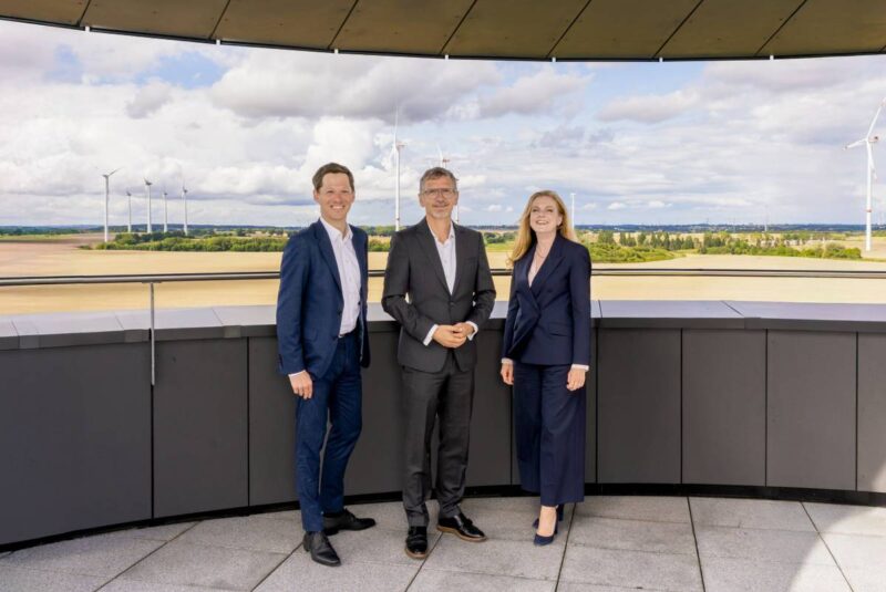 Der Vorstand der Enertrag, bestehende aus Simon Hagedorn, Gunar Hering, Anne Bendzulla vor einem Windpark.