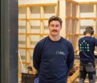 Enpal-Schulungsleiter Paul Hauer vor einer Trainingsstation für PV-Fachkräfte.