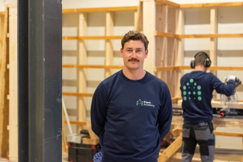 Enpal-Schulungsleiter Paul Hauer vor einer Trainingsstation für PV-Fachkräfte.