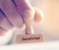 Im Bild ein Stempel mit der Aufschrift genehmigt als Symbol für die Förderung für Photovoltaik-Anlagen in der EU.