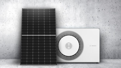 Photovoltaik-Modul und weiße Wärmepumpe vor grauer Betonwand - von Enpal