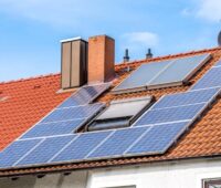 Ein Haus mit Photovoltaik-Anlage auf dem Dach, der Betreiber kann eine erhöhte Volleinspeisevergütung beantragen, wenn er auf den Eigenverbrauch verzichten will.
