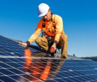 Ein Installateur bringt ein Photovoltaik-Modul auf dem Dach an, Enpal war 2024 Marktführer bei Photovoltaik-Installationen in Europa.