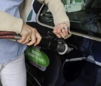 Autofahrerin betankt ein Fahrzeug mit Biomethan.