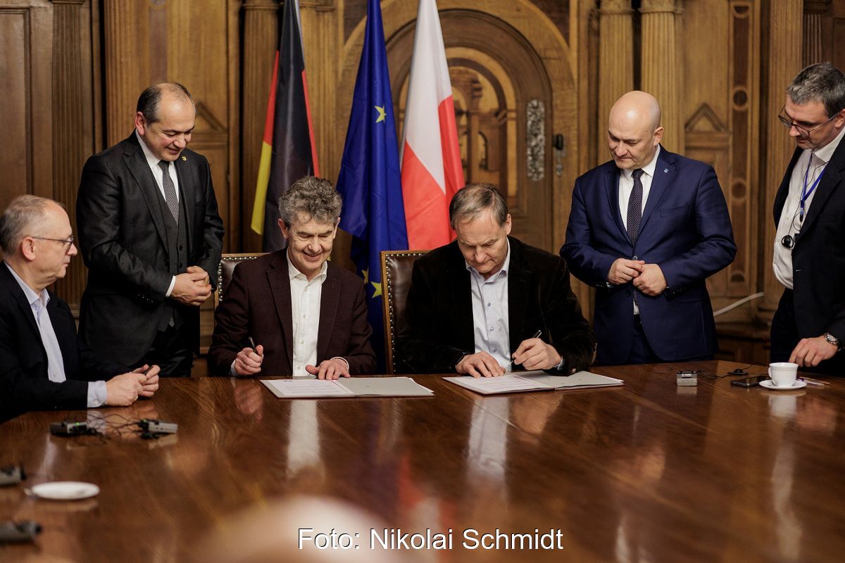 Mehrere Personen bei feierlicher Vertragsunterzeichnung im historischen Ambiente.