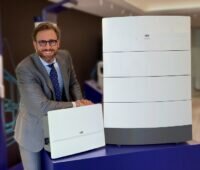 Zu sehen ist Filippo Carzaniga, Vorsitzender bei Fimer, der die neuen Photovoltaik-Wechselrichter und den PV-Speicher für den Heimbereich zeigt.