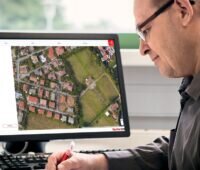 Im Bild ein Mann vor einem Laptop, auf dem die Fischer-Software Solarpanel-Fix läuft.