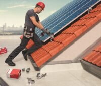 Im Bild ein Mann, der Photovoltaik-Montagesysteme von Fischer ausprobiert.