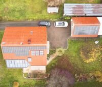 Luftaufnahme von zwei dörflichen Häusern mit PV-Dach