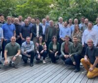 Frauen und Männer, die freundlich für ein Gruppenfoto posieren.