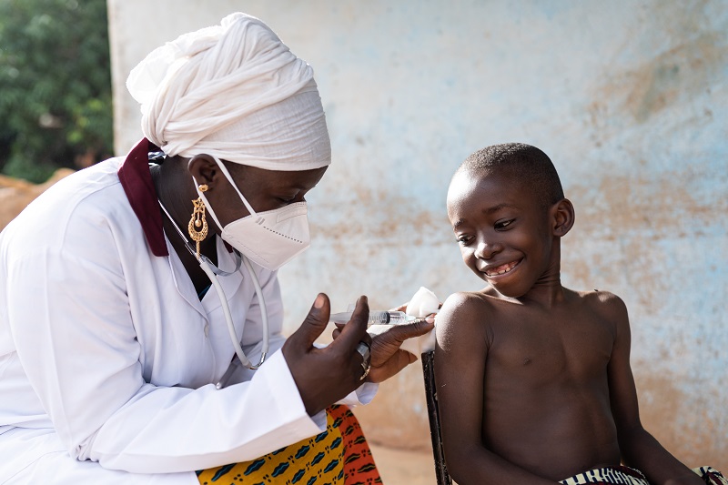 Zu sehen ist eine Krankenschwester in Afrika, die einem kleinen Jungen eine Spritze gibt. SophiA will solare Containerlösungen für Krankenhäuser in Afrika entwickeln.