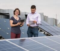 Zu sehen sind Studierende zwischen Photovoltaik-Modulen. Der Master-Studiengang Renewable Energy an der Frankfurt UAS vermittelt Fachkompetenz im Bereich erneuerbare Energien und Energietechnik.