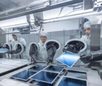 Wissenschaftler in Reinraumanzügen und im Labor arbeiten an Siliziumwafern.